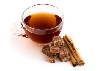 Cup of you with brown sugar cubes and cinnamon sticks, isolated on white background