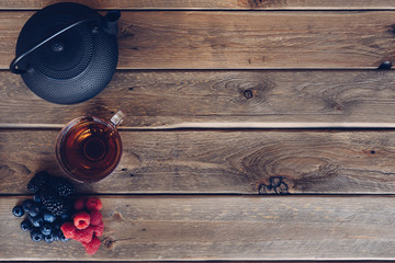 Flat lay of Cup of te and iron with dried fruit tea, cinnamon and fruits of the forest. vintage style