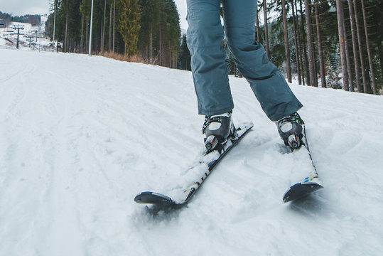 Woman Legs Ski Close Up. Snowed Hill On Background With Lift