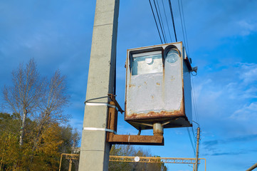 Old with a rust road surveillance camera for cars mounted on a concrete pillar.