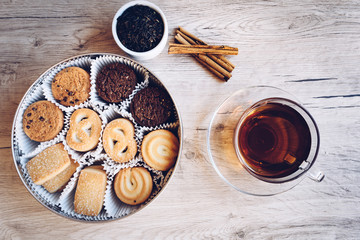 Fototapeta na wymiar flat lay of Danish butter cookies with a cup of tea and kettle, iron, dry leaves and cinnamon