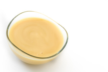 Bowl of homemade vanilla custard isolated on white background. Copyspace

