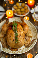 Festive baked chicken with rosemary on a festive table by candlelight