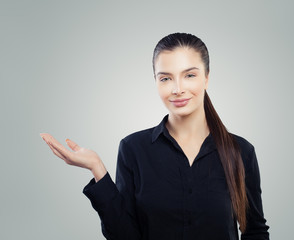 Smart business woman showing empty open hand. Young woman smiling, business and education concept