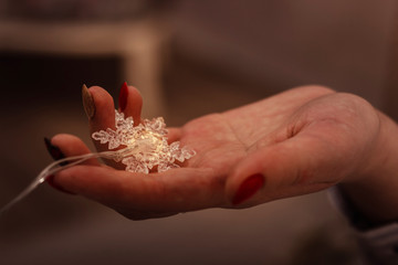 snowflake garland on the womans palm close-up