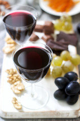 Creme de Cassis homemade liqueur served with grapes, nuts and chocolate. Rustic style.