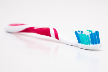 toothbrush with toothpaste on white background