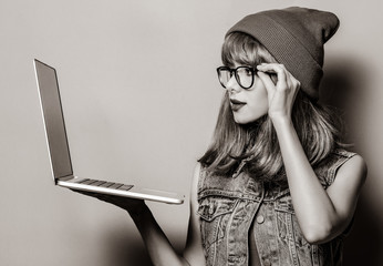 Portrait of young style hipster girl with laptop computer . Image in black and white color style