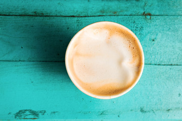 Coffee cup on turquoise wooden table top view