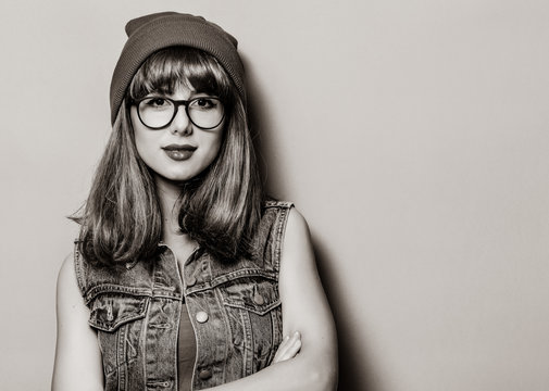 Portrait of young style hipster girl in hat and glasses . Image in black and white color style