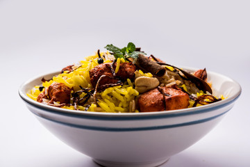 Indian Chicken Tikka Biriyani served in a bowl with yogurt. selective focus