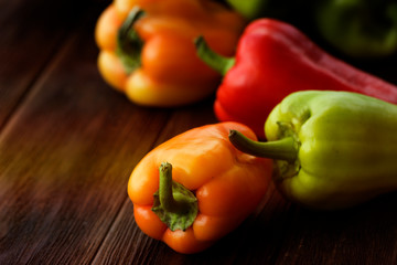 Green , yellow and red bell pepper on wooden background