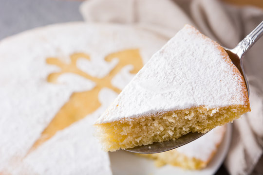 Tarta de Santiago. Traditional almond cake slice from Santiago in Spain on gray background. Close up