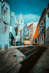 Summer cityscape of Lisboa. Red tram going down the hill along old traditional houses. sunny...