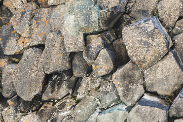Textured basalt background hexagonal stone pillars in a section. natural volcanic formations