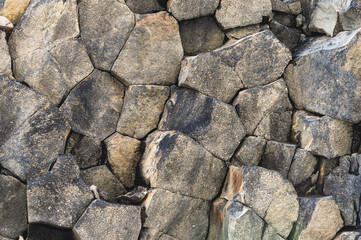 Textured basalt background hexagonal stone pillars in a section. natural volcanic formations