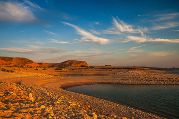 Beautiful and scenic landscape of the Lake Mead National Recreation Area shores, Nevada, at sunset with blue sky and white clouds, in summer..