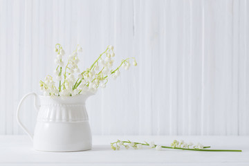 spring flowers in vase on white wooden background