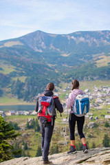 couple hiking in the mountain and enjoying view on the lake