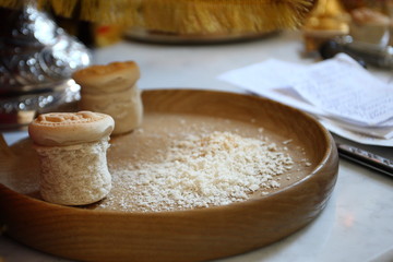 The Procurion liturgical liturgical bread used during Orthodox worship is located on a metal or wooden tray table