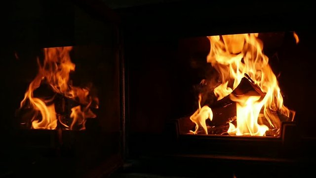 Two heaps of balks burning in a fireplace with inspiring forks of flame