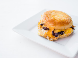Classic breakfast sandwich on a gluten free english muffin. Bacon, egg, and cheese on bread and served for brunch.