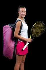 Female athlete posing with tennis racket against black background