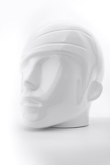 White plastic human head from mannequin as soft object with shadows, shades of gray, mild style concept