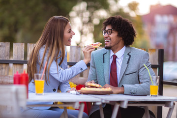 Happy young business team eating pizza in outdoor cafe.Business,food and people concept.