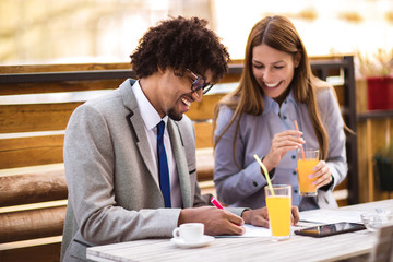 Business people discuss about the future project plan in outdoor cafe.