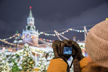 Obraz na płótnie Canvas Red Square, Moscow, Russia - December 29, 2018: A photographer is shooting a new 30.1 megapixel full-frame mirrorless interchangeable-lens camera Canon EOS R
