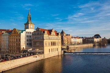 Fototapeta premium Golden light over the beautiful old town of Prague city during sunset at early spring seen from Charles Bridge