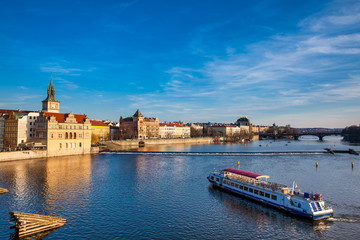 Obraz premium Boat navigating on Vlava river at sunset in Prague