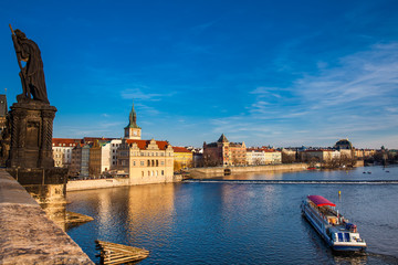 Obraz premium Boat navigating on Vlava river at sunset in Prague
