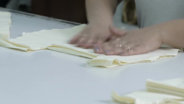 Cutting the fabric, sewing work. Cutting room, seamstress stacks the cut fabric blanks