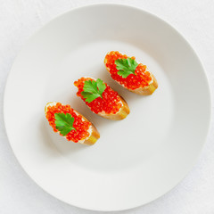 baguette slices with butter and red caviar decorated with parsley 