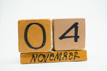 november 4th. Day 4 of month, handmade wood calendar isolated on white background. autumn month, day of the year concept