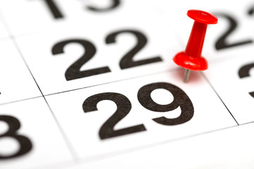 Pin on the date number 29. The twenty ninth day of the month is marked with a red thumbtack. Pin on calendar