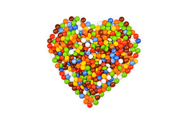 Heart made of multicolored  candies isolated on white background.