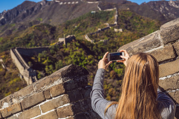 Happy cheerful joyful tourist woman at Great Wall of China having fun on travel smiling laughing...