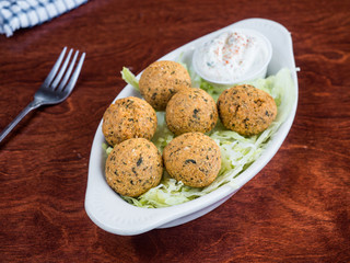Falafel appetizer with dipping sauce. A classic vegetarian Mediterranean dish made with garbanzo beans. Simple Greek food. 