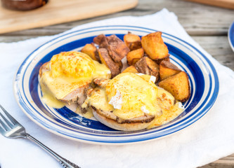 Homestyle eggs benedict with crispy hash browns served for brunch in Portland, Oregon.