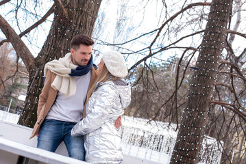 Fototapeta premium Romantic couple in love enjoying winter day together in Christmas decorated winter park 