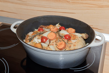 Cooking a roast duck in a roaster on a hot plate