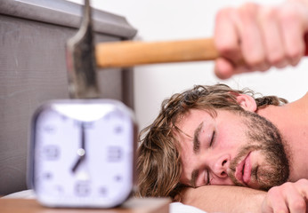Annoying ringing alarm clock. Man bearded annoyed sleepy face lay pillow near alarm clock. Guy...