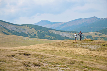 Fototapeta na wymiar Sporty hikers on path with trekking poles