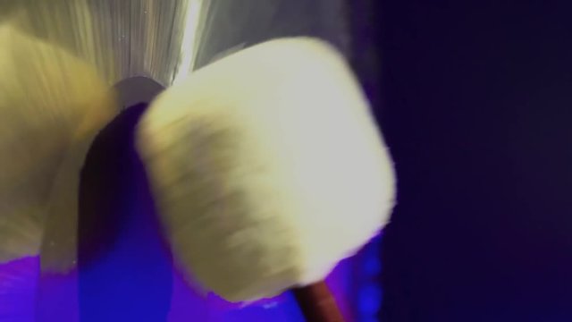 Beater close-up hitting a big gong with in a dark room.