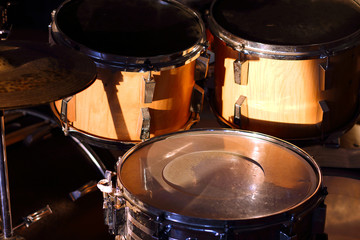 Drum set illuminated by the rays of the setting sun in a music studio. Closeup.