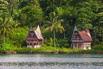 Houses on the shore of Samosir island in the middle of the volcanic lake Toba, Sumatra, Indonesia