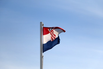 Flag of Croatia, blowing in the wind. Clear blue sky in the background.